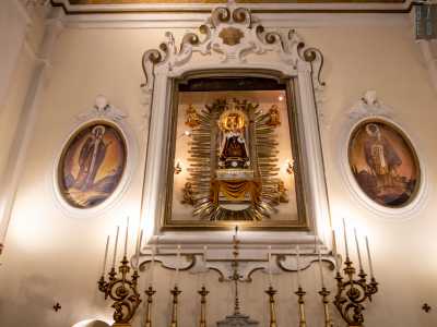 ...mostrando cos� finalmente la statua, adagiata su un tronetto dorato incorniciato da una raggiera e quattro angeli con strumenti musicali